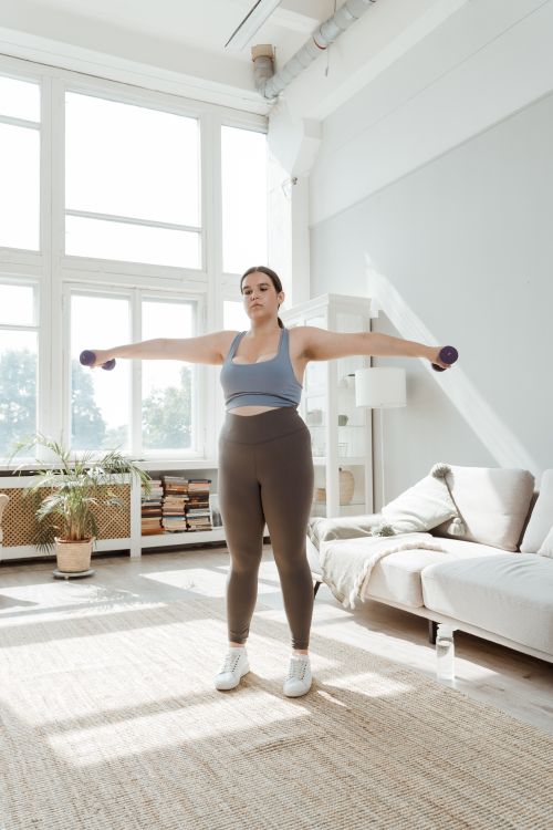 Stock photo of a woman using light weights at home